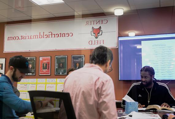 Image of students and faculty working collaboratively in the Center for Sports Communication.